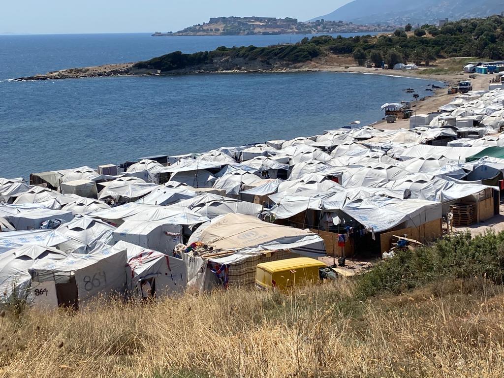 莱斯沃斯岛（Lesbos）虽已发出高温警报，但难民们仍可在圣艾智德团体服务的红色帐篷里找到所需的食物、和平学校、甚至友谊