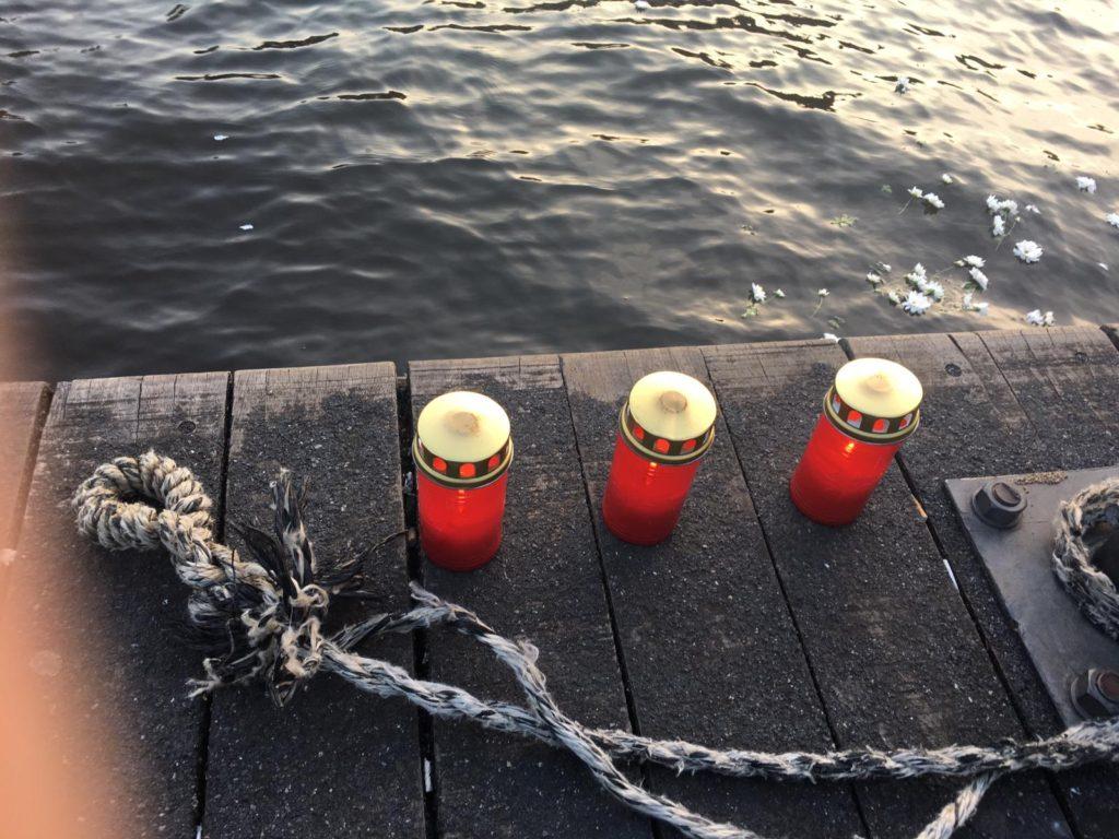Bloemen en lichtjes aan de oever van de rivier om de migranten te herdenken die op zee zijn omgekomen