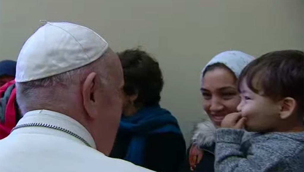 Pope Francis and the refugees from Lesbos unveiling the cross of migrants: